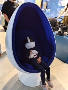 Niño dentro de una cápsula azul de realidad virtual en centro de interpretación marino
