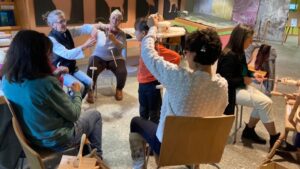 Grupo de personas en círculo participando en taller tradicional de hilado de lana en la Sierra de Francia.