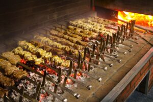 Asador tradicional con carnes y brochetas cocinándose sobre brasas ardientes en la Sierra de Francia.
