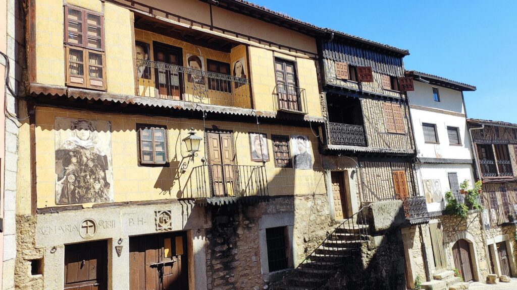 Fachadas coloniales de piedra y madera en Mogarraz, pueblo medieval de la Sierra de Francia con balcones y ventanas tradicionales.