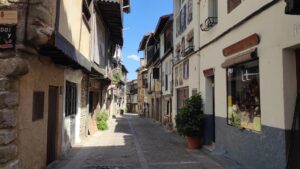 Calle empedrada de Mogarraz con casas blancas tradicionales, tiendas y arquitectura colonial de la Sierra de Francia.
