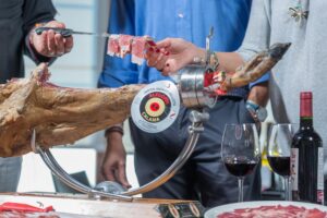 Degustación de Jamón Ibérico Alegría Cálama con vino tinto, mostrando corte tradicional en la Sierra de Francia.