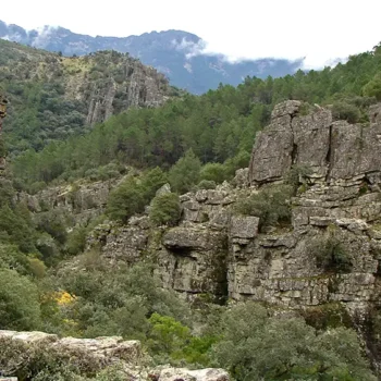 Paisaje de la Sierra de Francia con acantilados rocosos, vegetación verde y montañas al fondo
