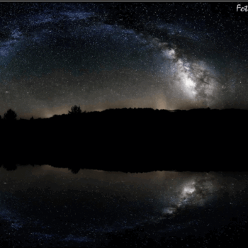 Vía Láctea reflejada en lago nocturno de la Sierra de Francia, bosque silhueteado bajo cielo estrellado.