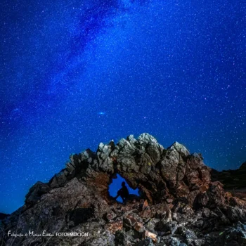 Silueta de montañero en rocas bajo cielo estrellado nocturno en la Sierra de Francia