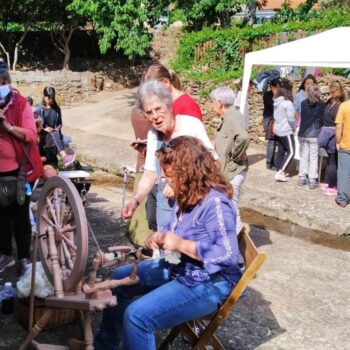 Demostración de hilado tradicional en festival de la Sierra de Francia con público observando artesanía local.