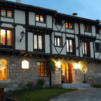 Hotel Antiguas Eras en La Alberca, edificio de arquitectura medieval con entramado de madera, iluminado al atardecer en la Sierra de Francia.