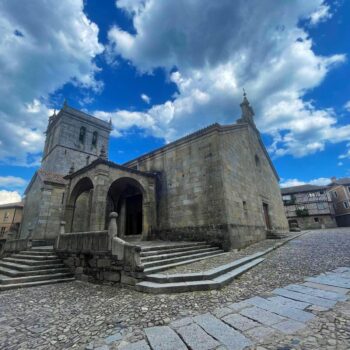 Iglesia de piedra con torre en plaza empedrada de La Alberca, pueblo medieval de la Sierra de Francia.