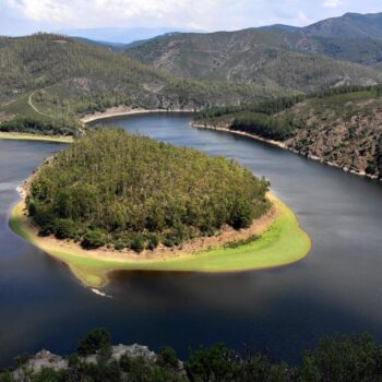 Meandro Melero en la Sierra de Francia: río sinuoso rodeado de bosques y montañas verdes con vegetación exuberante.