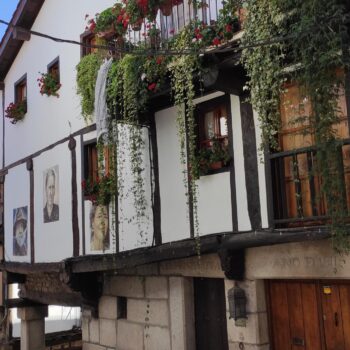 Casas tradicionales blancas con balcones floridos y enredaderas en pueblo colonial de la Sierra de Francia.