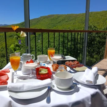 Desayuno gourmet en terraza con vistas a montañas verdes de la Sierra de Francia en Restaurante Porta Coeli.