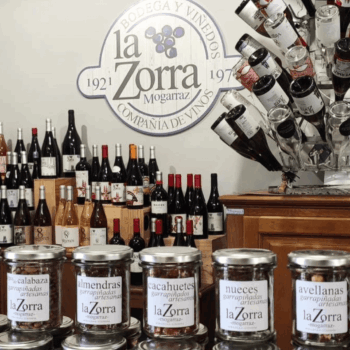 Bodega La Zorra: botellas de vino y frascos de frutos secos artesanales con logo de la empresa desde 1921.